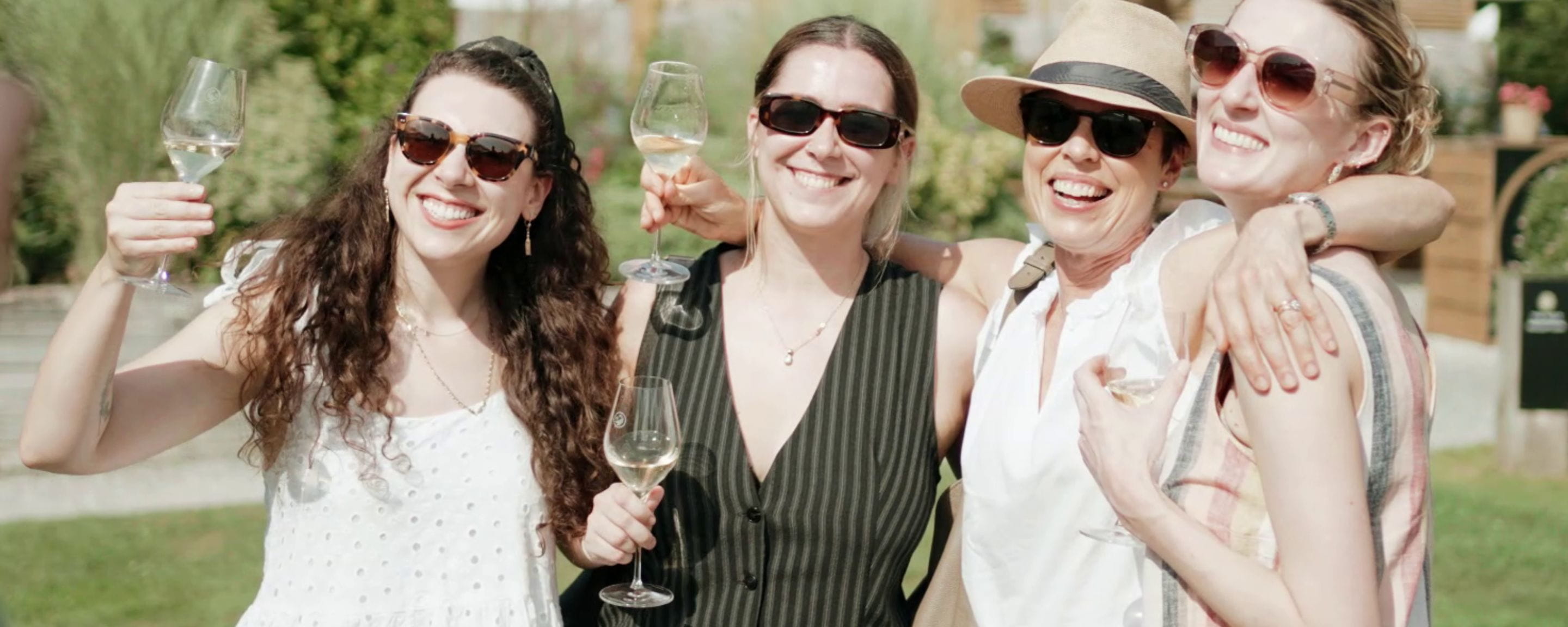 four women at a wine tasting drinking white wine