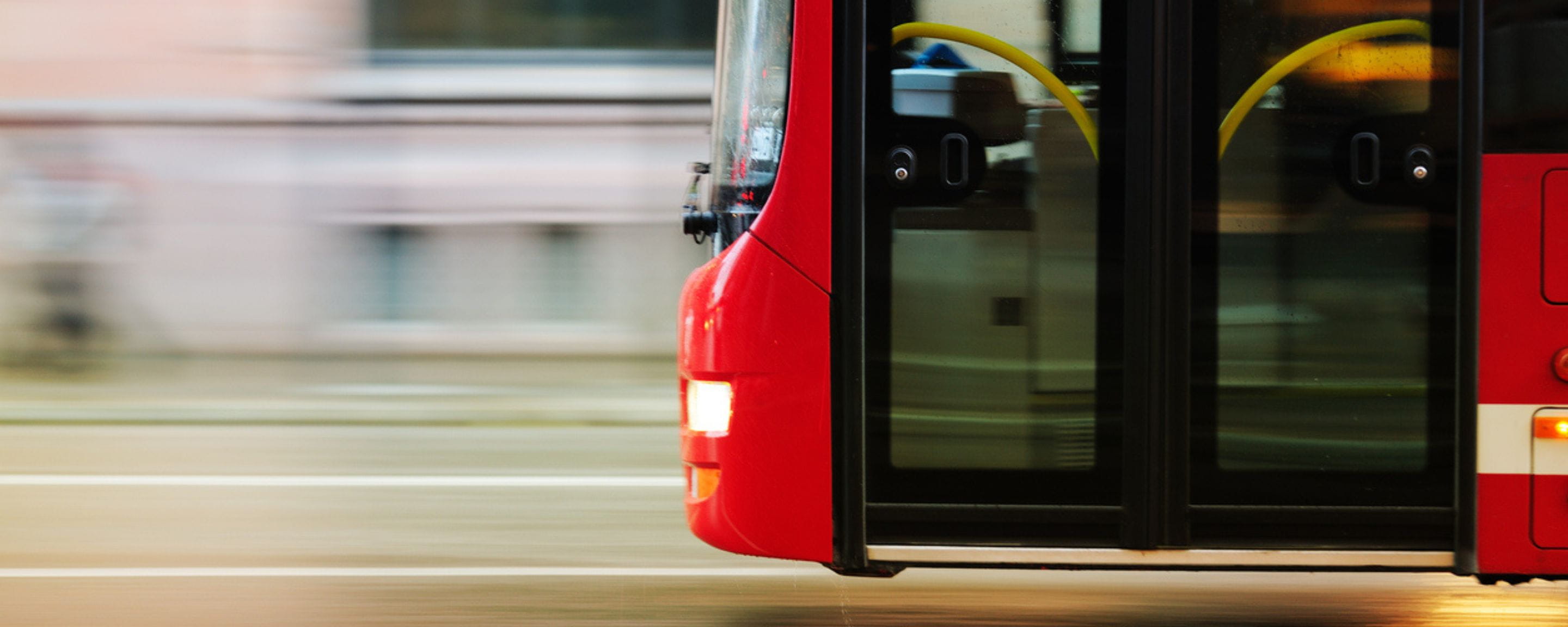 A red bus driving along the road